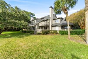 a house with a palm tree and a yard at Kingston Plantation - Richmond Park #7E in Myrtle Beach