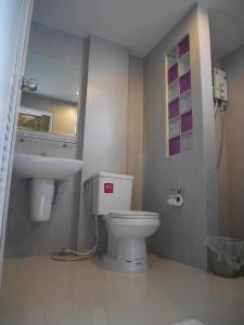 a bathroom with a toilet and a sink at Green Garden Place in Udon Thani