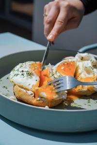 a person eating a plate of food with a fork at Millennium Hub & Hotel in Constanţa