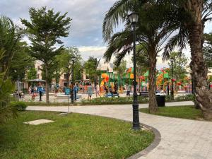 ein Park mit einem Spielplatz, Palmen und einem Lichtmast in der Unterkunft M&M homestay in Quang Tri