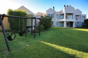 a playground in front of a large house at Ellefsen Golf Suite 108, Langebaan, 4-sleeper in Langebaan