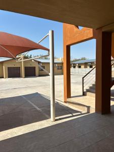 an empty parking lot with an umbrella in a building at MicasaKollections - Villa Ndahafa in Ongwediva