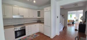 a white kitchen with white cabinets and a living room at LORO PARQUE PUERTO DE LA CRUZ in Puerto de la Cruz +35 photos