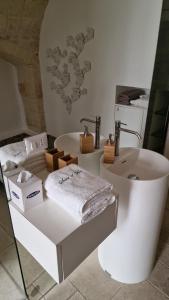 a white bathroom with a sink and a bath tub at Il Fico Luxury Suite & SPA in Polignano a Mare +14 photos