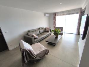 ein Wohnzimmer mit Sofa und Tisch in der Unterkunft Chambre entre mer et montagne in Barbaggio