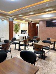 a conference room with tables and chairs and a projection screen at Kalu Hotel in Kabale