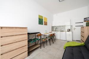 a kitchen and living room with a couch and a table at Łódź Urban Serenity Studio #11 by BookingHost in Łódź