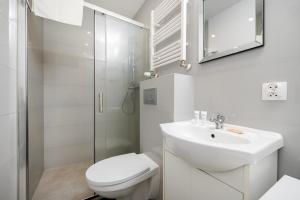 a white bathroom with a toilet and a sink at Łódź Urban Serenity Studio #11 by BookingHost in Łódź +10 photos