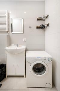 a washing machine in a bathroom with a sink at Łódź Urban Serenity Studio #11 by BookingHost in Łódź
