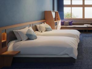 a hotel room with two beds and a window at OMO7 Yokohama by Hoshino Resorts in Yokohama