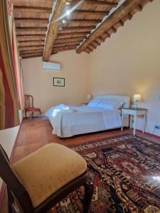 a bedroom with a bed and a chair and a table at Mammolino - Medieval Mini-villa with Jacuzzi and stunning views in Lucca