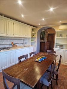 a kitchen with a wooden table and chairs at Mammolino - Medieval Mini-villa with Jacuzzi and stunning views in Lucca