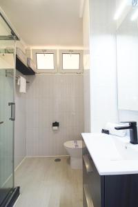 un bagno con lavandino e servizi igienici e due finestre di LosLocos beach a Suances Altre 11 foto
