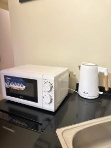 a white microwave sitting on top of a counter at Condo in Cagayan de Oro City in Cagayan de Oro