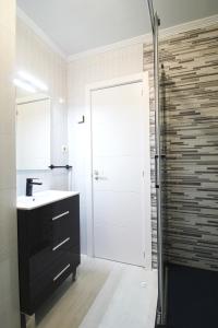 un bagno con lavandino e doccia di LosLocos beach a Suances