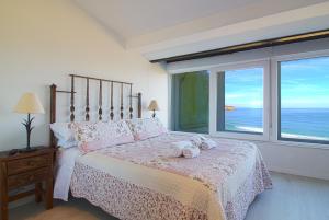 una camera da letto con un letto con vista sull'oceano di LosLocos beach a Suances