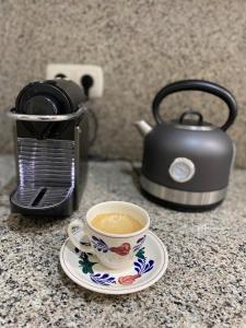 a cup of coffee sitting on a counter with a tea kettle at Lovely 2 bedrooms apartment main square Plasencia in Plasencia +9 photos