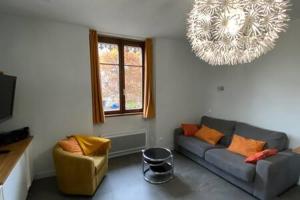 L'Ecrin de Verdure du Centre Ville في إيكس لي بان: غرفة معيشة مع أريكة ونافذة