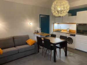 L'Ecrin de Verdure du Centre Ville في إيكس لي بان: غرفة معيشة مع أريكة وطاولة مع كراسي