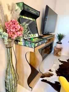 escritorio con ordenador portátil y jarrón con flores en Villa Sirey & SPA - Design - Centre-ville - Jacuzzi & Sauna, en Brive-la-Gaillarde