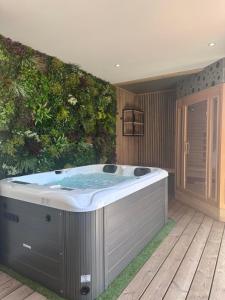jacuzzi frente a una pared verde en Villa Sirey & SPA - Design - Centre-ville - Jacuzzi & Sauna, en Brive-la-Gaillarde