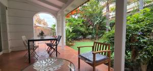 a porch with a table and chairs and a garden at LORO PARQUE PUERTO DE LA CRUZ in Puerto de la Cruz