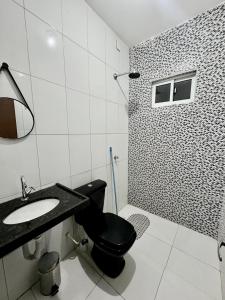 a bathroom with a black toilet and a sink at Temporada AK Freitas in Parnaíba