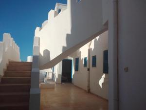 a hallway of a white building with a staircase at taguermess 2 in Midoun