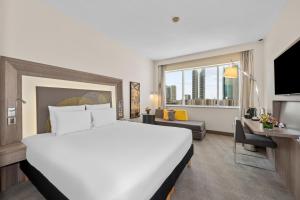 a hotel room with a large bed and a large window at Novotel Dubai World Trade Centre in Dubai