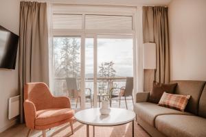 StraumenにあるJegtvolden Fjordhotellのソファとテーブルと窓のあるリビングルーム