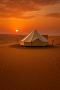a tent in the middle of the desert at sunset at Sahara Dream Camp in Al Raka