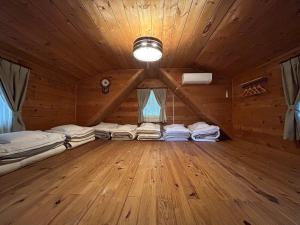 a room with several beds in a wooden attic at 松川湖の目の前に佇む貸切ログハウス ファミーユ松川湖 in Ito