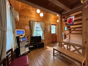 a living room of a log cabin with a tv at 松川湖の目の前に佇む貸切ログハウス ファミーユ松川湖 in Ito