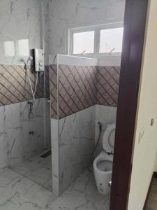にあるบ้าน กัญณภัทร โฮมสเตย์のトイレと窓のあるバスルーム