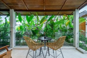 a patio with a table and chairs and plants at Reconnect in Ubud - Peaceful Living at Sarang Apartments 1 in Ubud +4 photos
