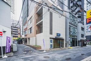 an empty street in a city with tall buildings at SLL Urban Suites Akasaka in Tokyo