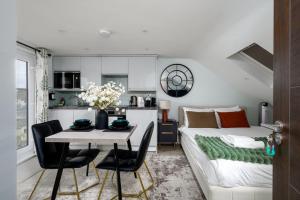 ein Wohnzimmer mit einem Bett und einem Tisch und Stühlen in der Unterkunft Greenford Apartments in Perivale
