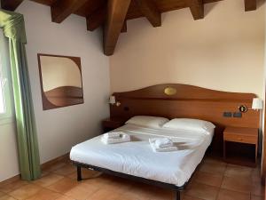 a bedroom with a bed with two towels on it at Hotel Conte Luna in Bologna