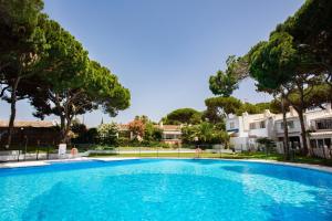 Sitio de CalahondaにあるCasa Tek Mijasの木々と家々が並ぶ青い大型スイミングプール