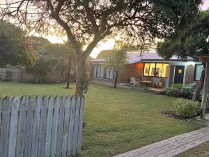 a house with a fence in a yard at sunbird cottage in Sedgefield