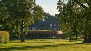 a large building in the middle of a park with trees at Rockliffe in Darlington