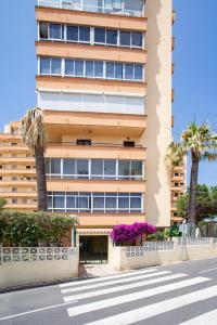 Sitio de CalahondaにあるCasa Tek Mijasの通りの前にヤシの木が茂る高い建物