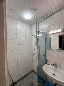 a bathroom with a glass shower and a sink at Arctic Shaman Adventures -Jurtta in Köngäs +104 photos