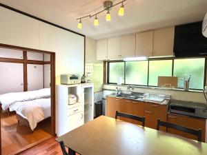 a kitchen with a table and a bed in a room at かみくまハウス in Kumamoto +16 photos