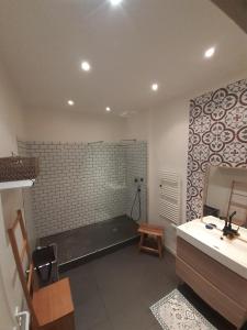 a bathroom with a bench and a sink and a mirror at Chez Anna- Centre-ville - Petit-déjeuner in LʼIsle-sur-la-Sorgue