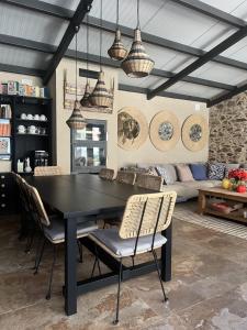 Un comedor con una mesa y sillas negras. en Casa Rural La Real de Guadalupe, en Guadalupe