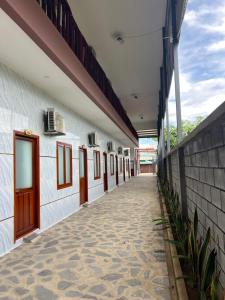an empty hallway of a white building with windows at Nhà Nghỉ NHẬT TIÊN in Tân Phú