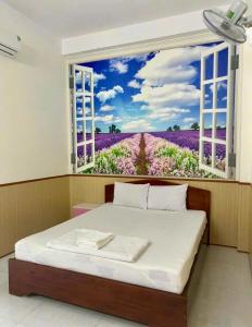 una camera da letto con una finestra che si affaccia su un campo di fiori di Nhà Nghỉ Kim Phượng Vũng Tàu a Vung Tau Altre 4 foto