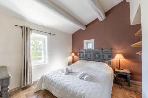 a bedroom with a large white bed and a window at Le Major in Cadenet