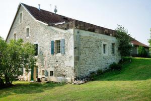 ein altes Steinhaus mit einem Rasenhof in der Unterkunft Duplex dans grande ferme rénovée in Divonne-les-Bains